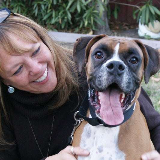 Photo of a woman smiling at a boxer dog