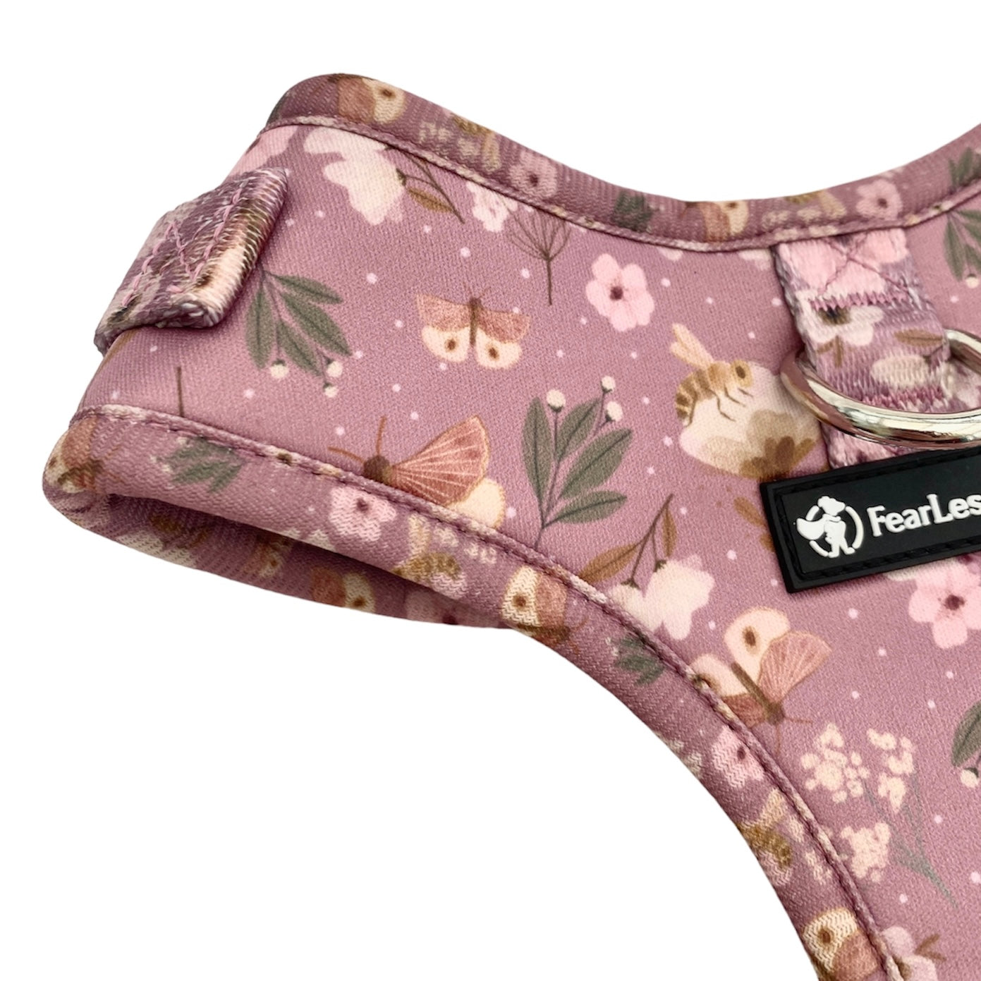 a close up photo of part of a no pull dog harness in dusty rose pink with butterflies and bees