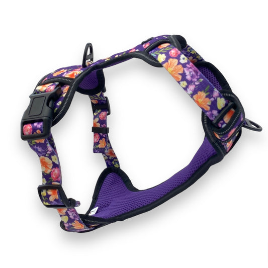 a 3d image of a purple floral no escape dog harness from fearless pet the harness has a front and back clip and a side buckle