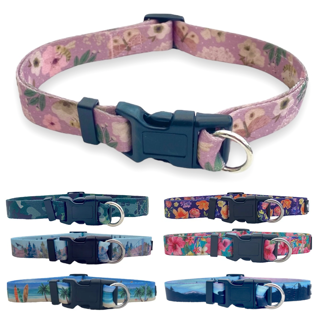 a photo of seven different prints of the safe cinch collars from  fearless pet there is pink butterflies, green camo, forest, beach, purple floral, hawaiian floral and northern lights dog collars, 