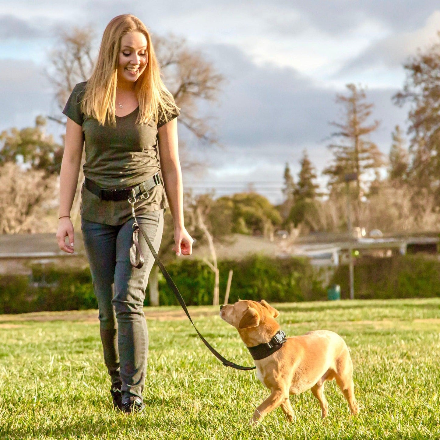 photo of a girl walking a dog hands-free at a park